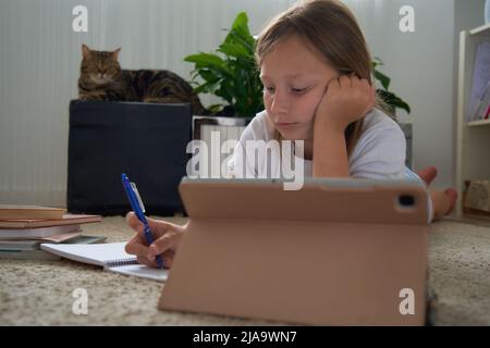 una ragazza fa i suoi compiti su un tablet Foto Stock