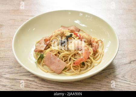 piccante mescolare gamberi di spaghetti fritti con affettare di maiale al prosciutto e foglia di basilico sul piatto Foto Stock