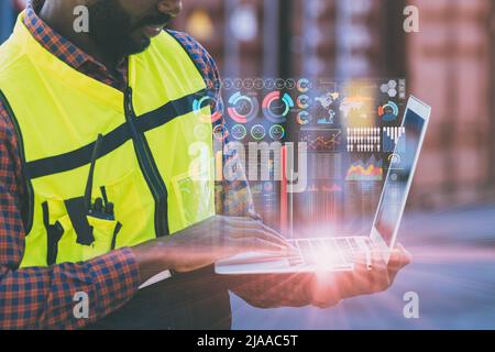 il personale tecnico che utilizza il computer portatile monitora la schermata dei dati aziendali durante la spedizione del carico al porto. Foto Stock