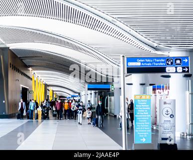 Gruppo di passeggeri che camminano agli arrivi, cancelli di trasferimento, voli collegati all'aeroporto Havalimani di Istanbul - IST Airport interior, Turchia Foto Stock