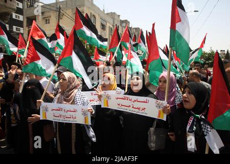 Khan Younis, Gaza. 29th maggio 2022. I palestinesi ondano bandiere palestinesi durante una protesta per le tensioni nella moschea al-Aqsa di Gerusalemme, a Khan Younis, nella striscia meridionale di Gaza, domenica 29 maggio 2022. Ore prima della marcia delle bandiere israeliane per celebrare la Giornata di Gerusalemme, Che commemora l'unificazione della città dopo che Israele annessa la porta est di Damasco nel 1967. Gerusalemme si sta preparando a una controversa "marcia di bandiera” da parte degli israeliani che ha scatenato l'allarme di una nuova escalation da parte delle fazioni palestinesi. Foto di Ismael Mohamad/UPI Credit: UPI/Alamy Live News Foto Stock