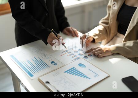 Primo piano vista dall'alto di diversi uomini d'affari collaborare insieme a discutere le statistiche finanziarie dell'azienda, colleghi multirazziali dipendenti Foto Stock