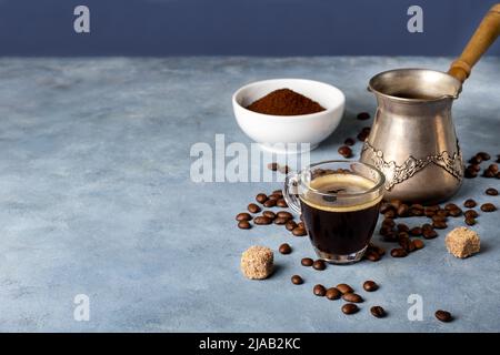 Macchina per il caffè turco, tazza di vetro, caffè macinato e chicchi di caffè Foto Stock