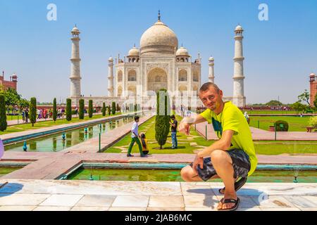 Il viaggiatore e il turista pone di fronte al famoso Taj Mahal in Agra India Mogul marmo mausoleo e panorama del famoso 17th secolo simmetrico g Foto Stock