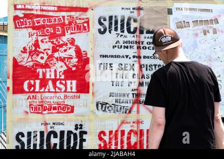 Bristol, Regno Unito. 28th maggio 2022. Un artista di strada usa uno stencil per ricreare vecchi poster di concerto di Punk Rock durante il festival di Street art di Bristol Upfest Foto Stock
