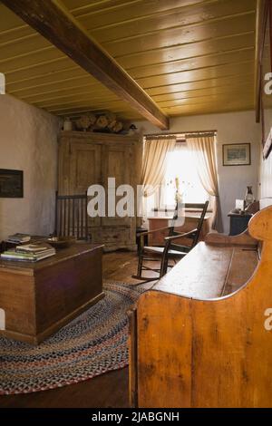 Cassettoni antichi, sedie a dondolo, armadio e mobili in soggiorno all'interno del vecchio casolare di Canadiana circa 1840 casa in pietra di campo. Foto Stock