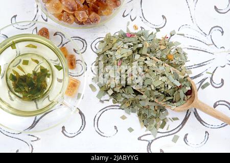 Infusione di erbe di tè di citronella in una pala di tazza di vetro e filtro del tè Foto Stock