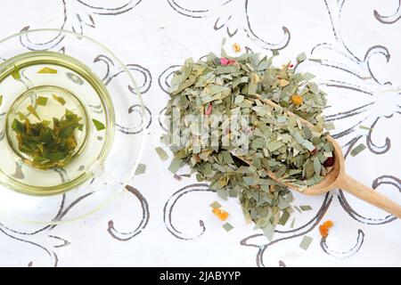 Infusione di erbe di tè di citronella in una pala di tazza di vetro e filtro del tè Foto Stock