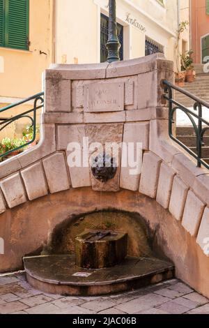 Fontana su Place du Conseil a Villefranche-sur-Mer sulla Costa Azzurra. Un getto d'acqua fluisce dalla bocca del leone. Costa Azzurra. Foto Stock