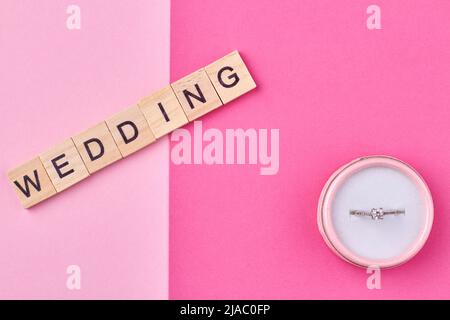 L'iscrizione MATRIMONIO su cubetti di legno e scatola regalo con anello. Concetto di proposta di matrimonio. Foto Stock