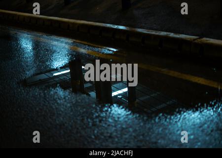 Riflesso di un parcheggio a più piani in un pozzanghere, situato nell'aeroporto internazionale di Manchester, Greater Manchester, Regno Unito. Foto Stock