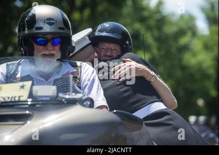 Washington, Stati Uniti. 29th maggio 2022. Personale Sgt. Tim Chambers, noto come 'The Saluting Marine', abbraccia un motociclista che partecipa al 'Rolling Thunder', una dimostrazione per portare consapevolezza ai prigionieri di guerra e membri militari mancanti in azione, vicino Constitution Avenue a Washington, DC Domenica, 29 maggio 2022. Foto di Bonnie Cash/UPI Credit: UPI/Alamy Live News Foto Stock