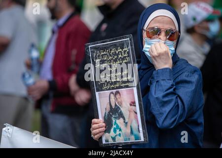 Un manifestante algerino detiene una carta con una foto dei suoi cari rapiti durante la protesta. A quattro anni dalla diaspora algerina, il movimento Hirak continua a lottare per la democrazia a Montreal. Organizzato da Tous unis pour notre Algerie, centinaia di manifestanti si sono riuniti davanti al Consolato algerino per chiedere la rimozione degli attuali leader politici, guidati dal presidente Abdelmajid Tebboune. Citando la corruzione cronica e la mancanza di risoluzioni prevedibili, i manifestanti hanno definito il governo un governo mafioso. Foto Stock