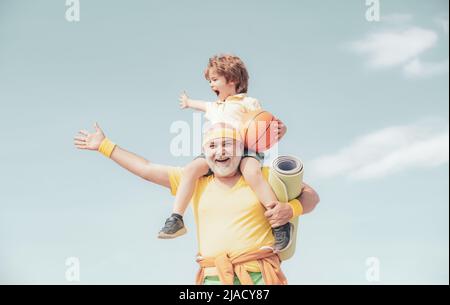 Amo lo sport. Stile di vita familiare sano. Uomo sportivo anziano e ragazzo giovane che si allenano al mattino - spazio per le copie. Riabilitazione. Nonno e figlio Foto Stock