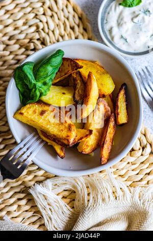 Vista dall'alto di una ciotola di patate arrosto con salsa panna acida Foto Stock