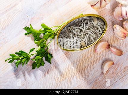 Anguille sottaceto in lattina aperta con aglio a tavola, nessuno Foto Stock