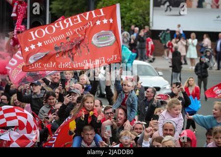 Un giovane sostenitore sorregge una bandiera di Liverpool mentre la squadra del Liverpool FC festeggia durante la parata degli autobus a cielo aperto attraverso la città Foto Stock