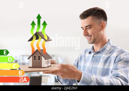 Architetto maschile con modello di casa in ufficio. Concetto di efficienza energetica Foto Stock