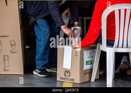 Un cittadino getta il suo voto nelle urne per le elezioni presidenziali colombiane. Il 29 maggio i colombiani hanno votato a favore del loro nuovo presidente. Dopo la delusione e l’insoddisfazione nei confronti del governo precedente, le aspettative erano di un cambiamento radicale. Alla fine della giornata, Gustavo Petro, rappresentante della sinistra colombiana, ha avuto più voti rispetto agli altri candidati, ma non ha superato il 50 per cento. Ciò significa che ci sarà una seconda votazione il 19 giugno, per stabilire chi vincerà tra Petro e Rodolfo Hernandez, che sorprendentemente è arrivato secondo in queste elezioni. Foto Stock