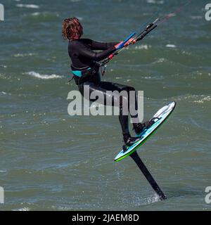 Maschio Kite Surfer lamina con barba e capelli lunghi sul mare. Primo piano Foto Stock