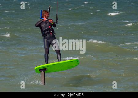 Maschio Kite Surfer lamina con barba e capelli lunghi sul mare. Primo piano Foto Stock