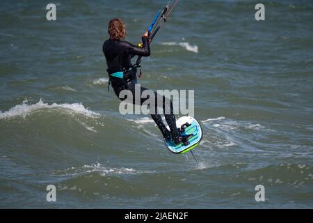 Maschio Kite foglio Surfer con capelli lunghi sul mare. Indietro vista ravvicinata Foto Stock