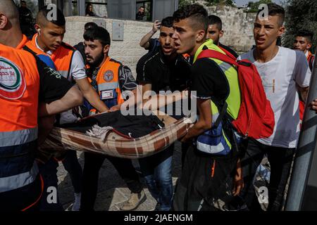 Gerusalemme, Israele. 29th maggio 2022. I medici portano via un uomo che è stato ferito durante gli scontri con gli israeliani che hanno preso parte alla marcia della bandiera, un raduno organizzato dagli israeliani nazionalisti che segna il giorno di Gerusalemme. Credit: Ilia Yefimovich/dpa/Alamy Live News Foto Stock