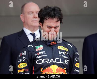 Monaco Ville, Monaco. 29th maggio 2022. Motorsport: Formula 1 World Championship, Gran Premio di Monaco, gara: Il pilota toro rosso Sergio Perez del Messico è superato con emozione dopo la sua vittoria mentre si alza sul podio davanti alla famiglia principesca di Monaco durante l'inno nazionale. Credit: Hasan Bratic/dpa/Alamy Live News Foto Stock