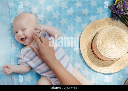 Neonato che trascorre del tempo all'esterno. Madre felice e sorridente con il suo neonato che passa il tempo nel parco. Ottenere aria fresca e luce solare naturale Foto Stock