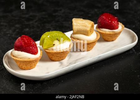 Tartina di frutta. Tartine di fragole, kiwi e banana su sfondo scuro. Primo piano Foto Stock