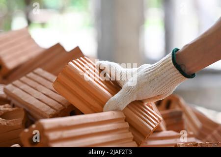 Vista ravvicinata del muratore in cantiere. Concetto di riparazione e materiali da costruzione Foto Stock