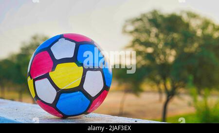 Pallavolo isolato sullo sfondo del tetto. Mattina, palla posto vicino alla parete del tetto. Attrezzature sportive Foto Stock