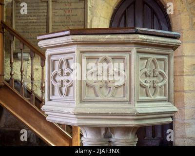 Fonte di pietra intagliata, interno della chiesa parrocchiale di St Michael e tutti gli Angeli nella città di Broadway, Cotswolds, Worcestershire, Regno Unito Foto Stock