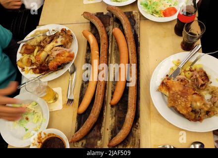 Primo piano salsicce tedesche e zoccoli di maiale fritti con birra ghiacciata, insalata di coleslaw e salse da immersione assortite Foto Stock