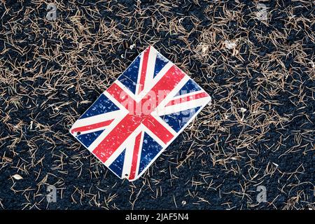 Un pezzo scartato di conigliatura, una bandiera Union Jack, che giace sul marciapiede. Foto Stock