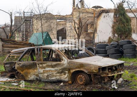 Auto bruciata durante la guerra in Ucraina. Edifici distrutti, strade. Tecnica di Ucraina civile Foto Stock