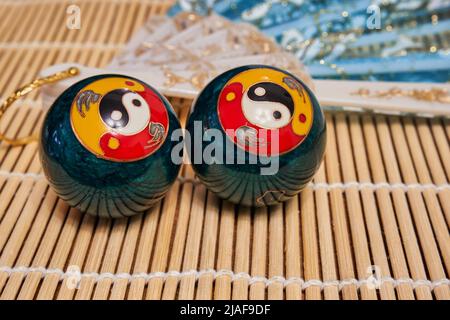 Palle da meditazione cinesi e un ventilatore. Palline di Baoding con simbolo yin-yang Foto Stock