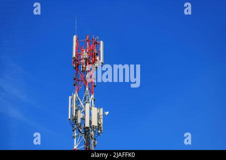 Traliccio di telecomunicazioni con ripetitori di segnale e antenne contro il cielo blu per tecnologia wireless e concetto di industria di radiodiffusione, spazio copia incl Foto Stock