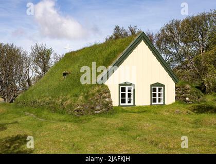 La chiesa di Hofskirkja con tetto in erba nel villaggio di Hof, nel sud dell'Islanda Foto Stock