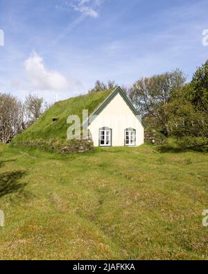 La chiesa di Hofskirkja con tetto in erba nel villaggio di Hof, nel sud dell'Islanda Foto Stock