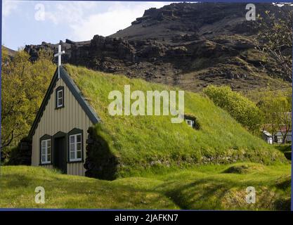 La chiesa di Hofskirkja con tetto in erba nel villaggio di Hof, nel sud dell'Islanda Foto Stock