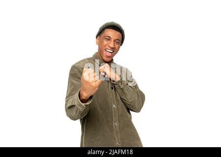 Ritratto di felice urlante bell'uomo in piedi con il volto eccitato e gioire la sua vittoria. Studio interno girato isolato su sfondo bianco Foto Stock