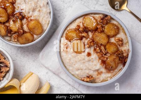 Porridge con banana caramellata e noci Foto Stock