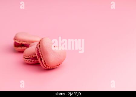 A forma di cuore Dolce macaron su sfondo rosa. Foto Stock