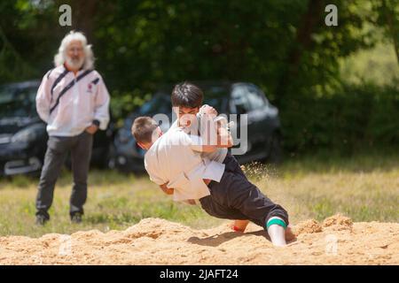 Pleyber-Christ, Francia - Maggio 29 2022: Due giovani che praticano il wrestling bretone (gouren) in corso sulla segatura. Foto Stock