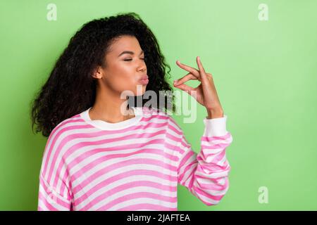 Ritratto di bella ragazza brunetta sognante che finge degustazione cibo pasto isolato su sfondo di colore verde chiaro Foto Stock