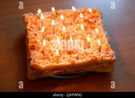 Torta con candele che bruciano primo piano. Torta con candele sul tavolo Foto Stock