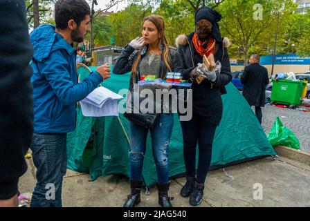 Parigi, Francia, giovani francesi volontari che distribuiscono cibo ai rifugiati siriani che vivono nelle tende di strada Foto Stock