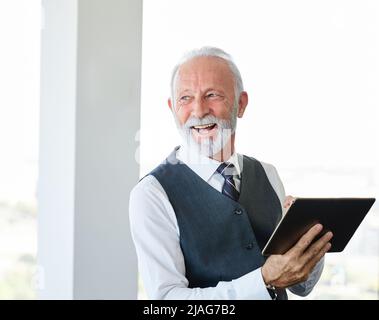 senior businessman tablet ufficio lavoro business computer casual maturo grigio capelli maturi anziano uomo ritratto Foto Stock