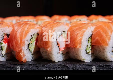 Piatto tradizionale cinese. Vista laterale ravvicinata del rotolo di sushi Philadelphia a fette. Foto Stock